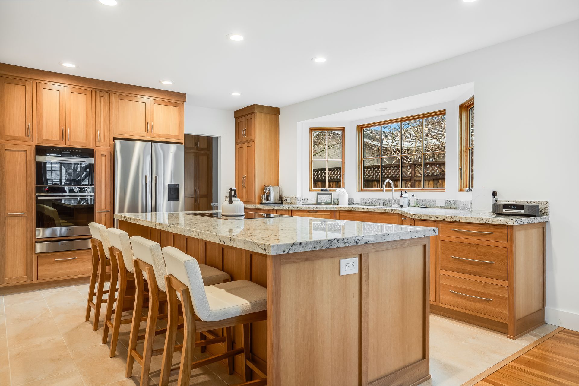 A kitchen with white cabinets and a large island in the middle.