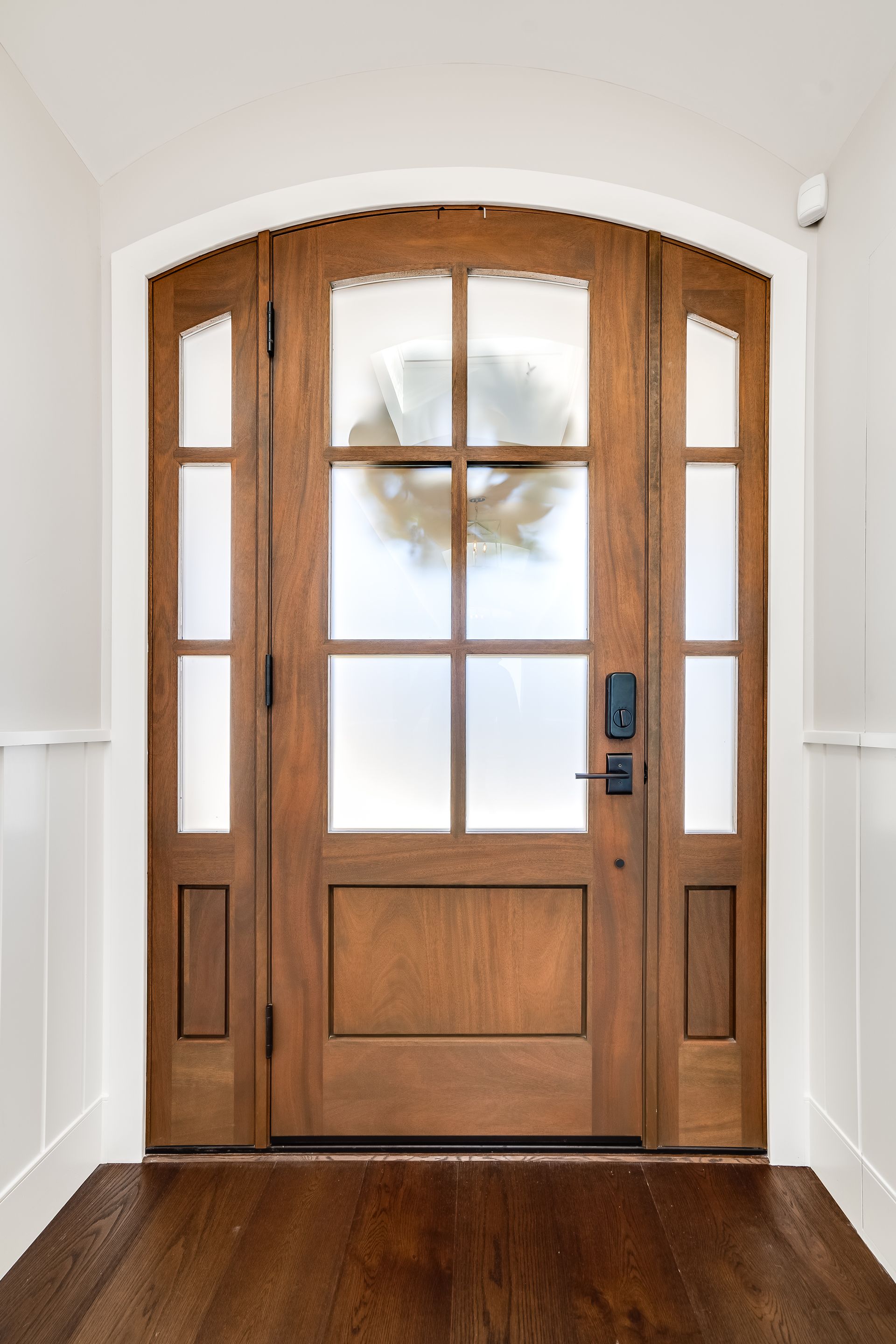 A wooden door with a wreath on it in a hallway.