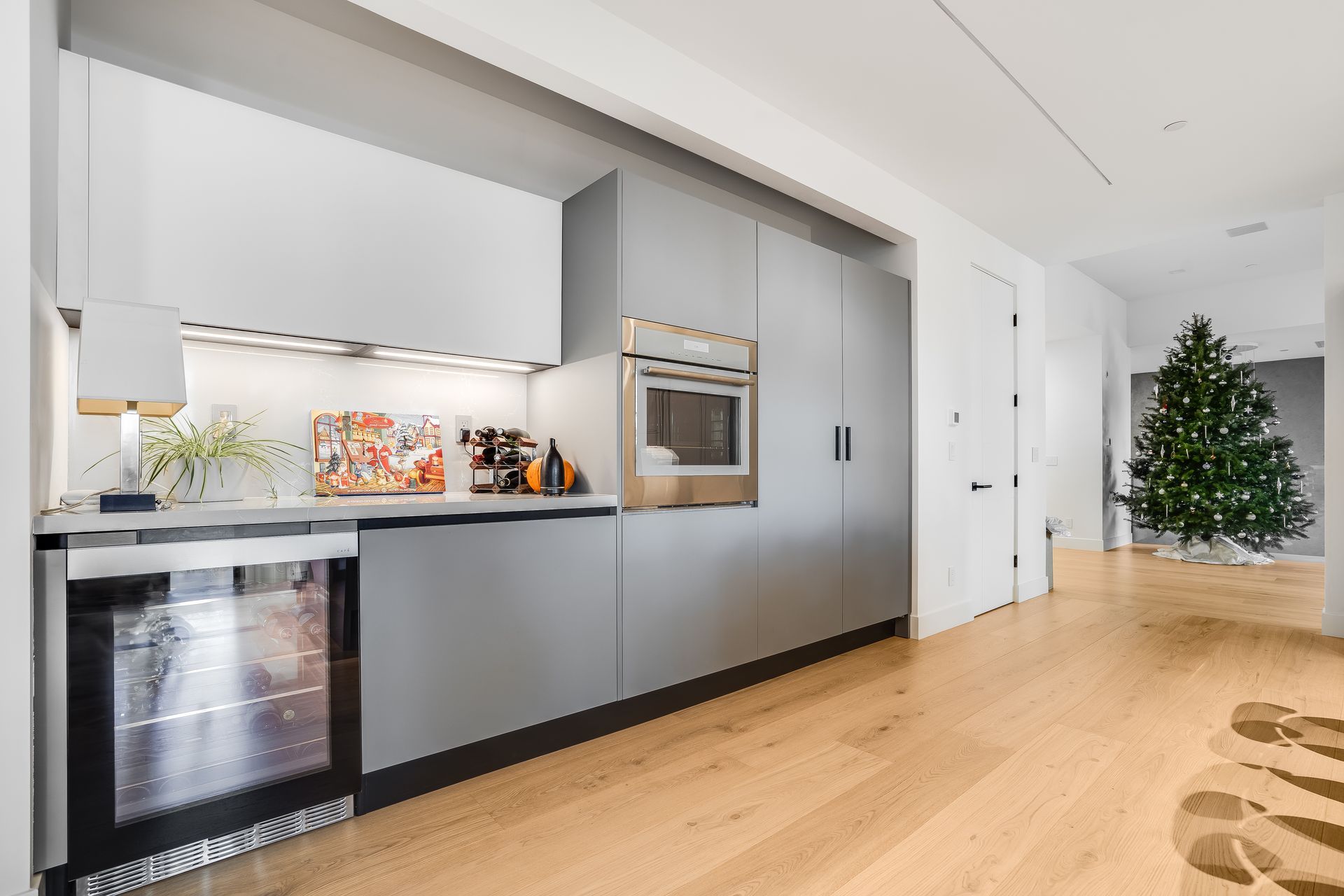A kitchen with a christmas tree in the background.