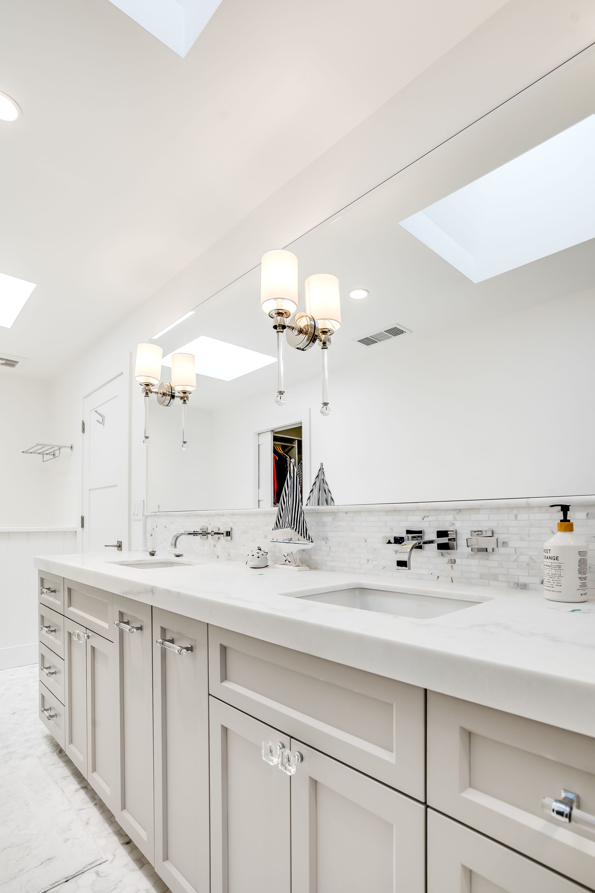A bathroom with a sink , mirror and skylight
