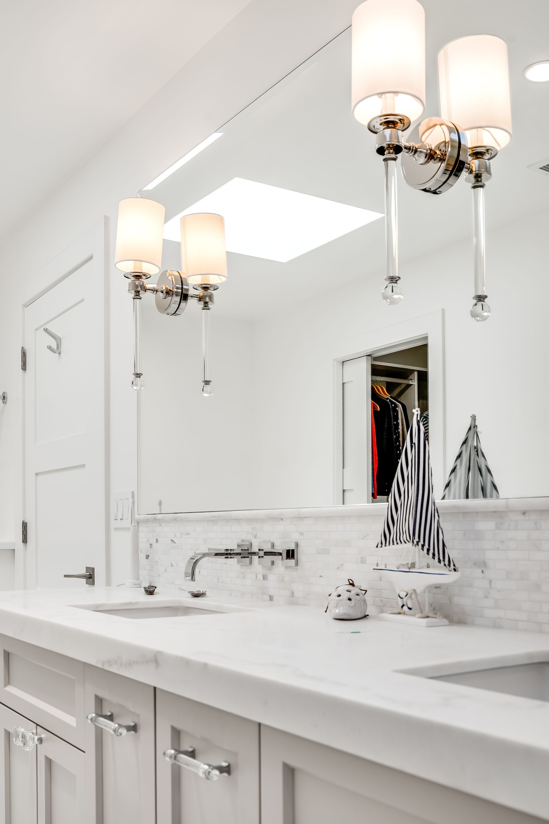 A bathroom with two sinks and a large mirror.