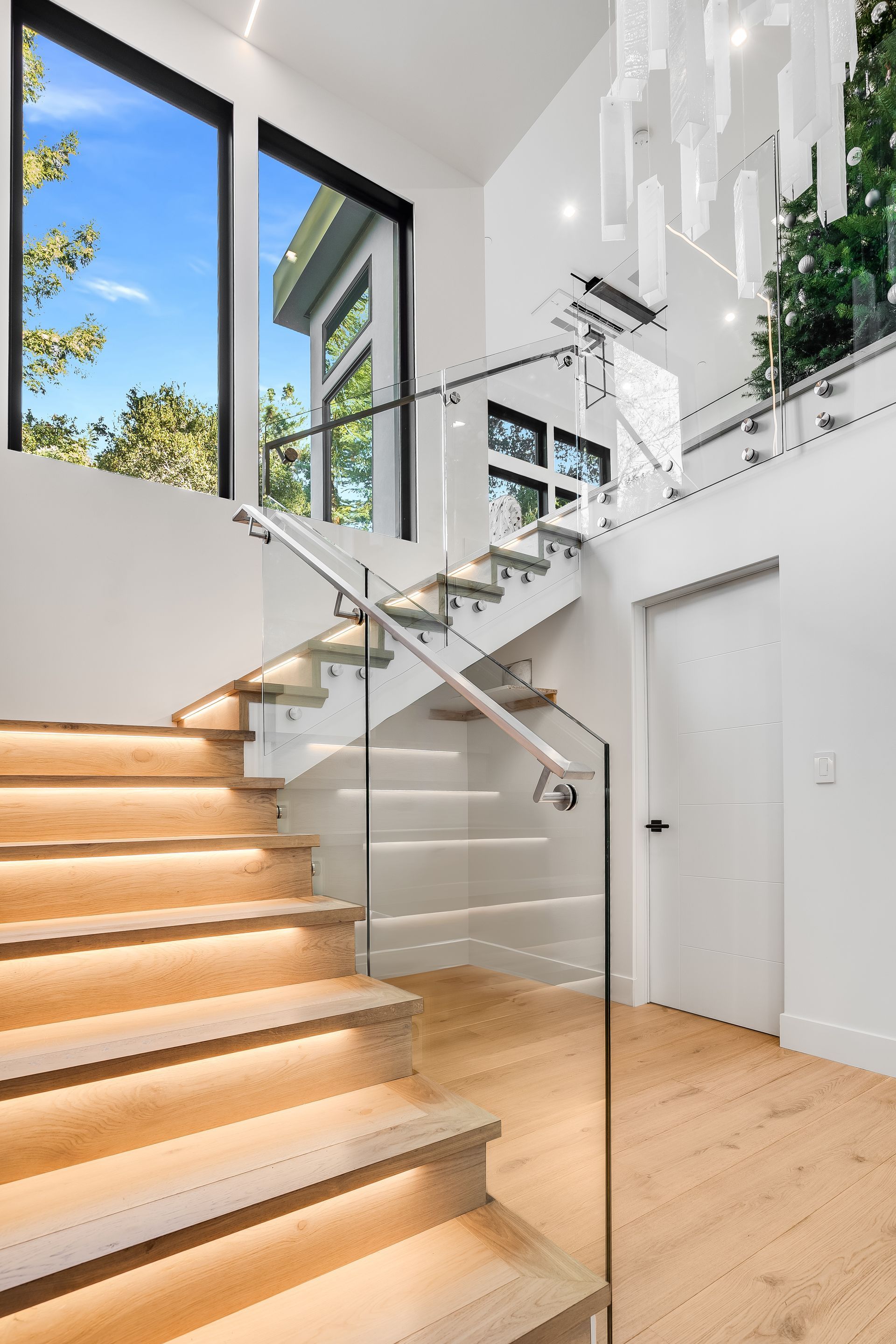 A modern staircase with wooden steps and a glass railing.
