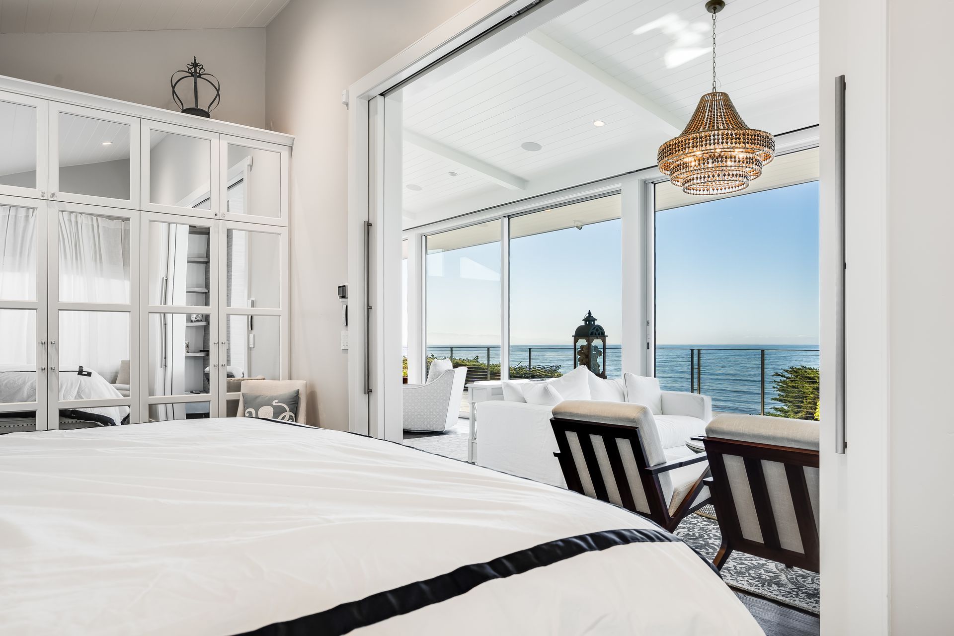 A bedroom with a bed and a view of the ocean.