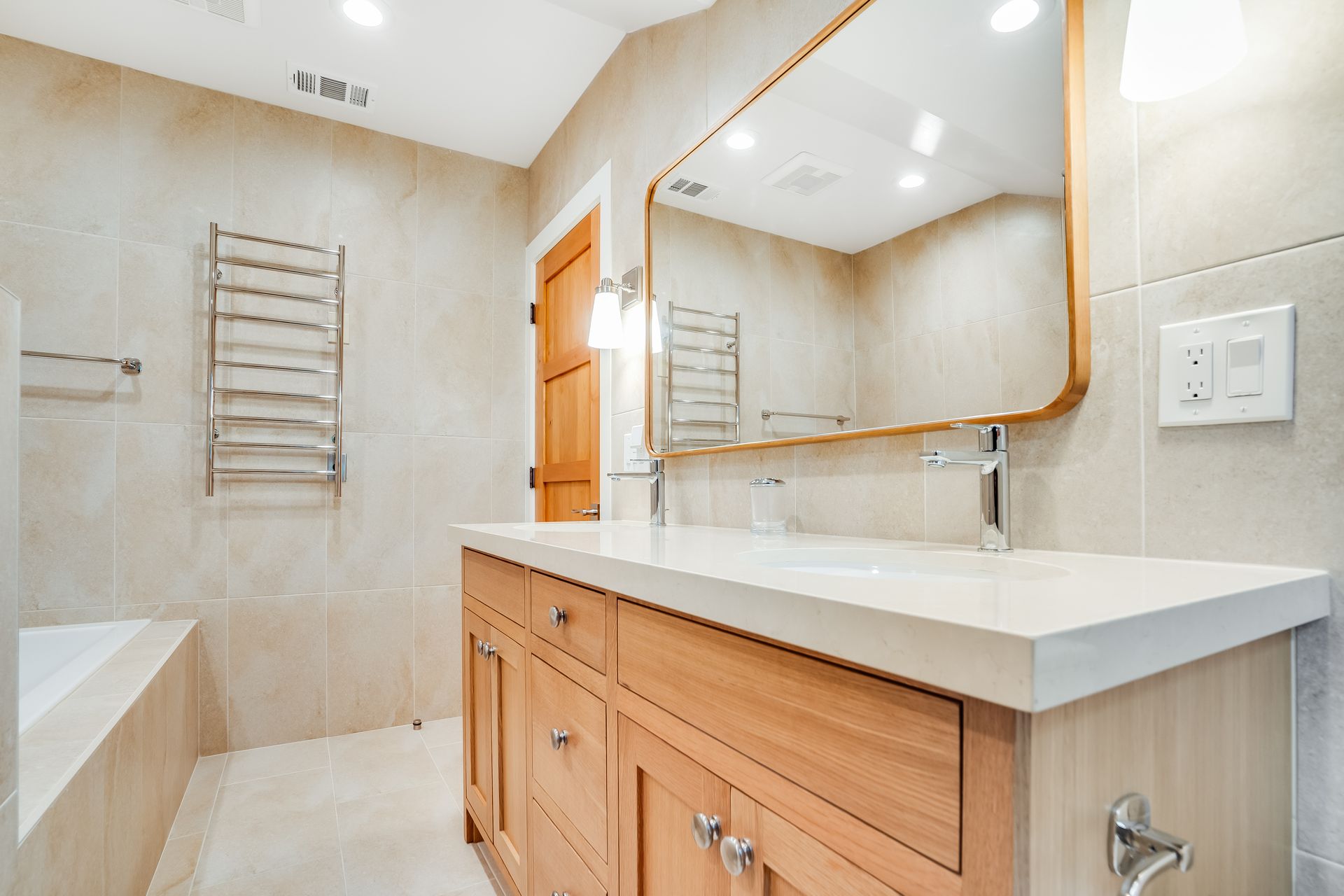 A bathroom with a double sink , mirror and towel rack.