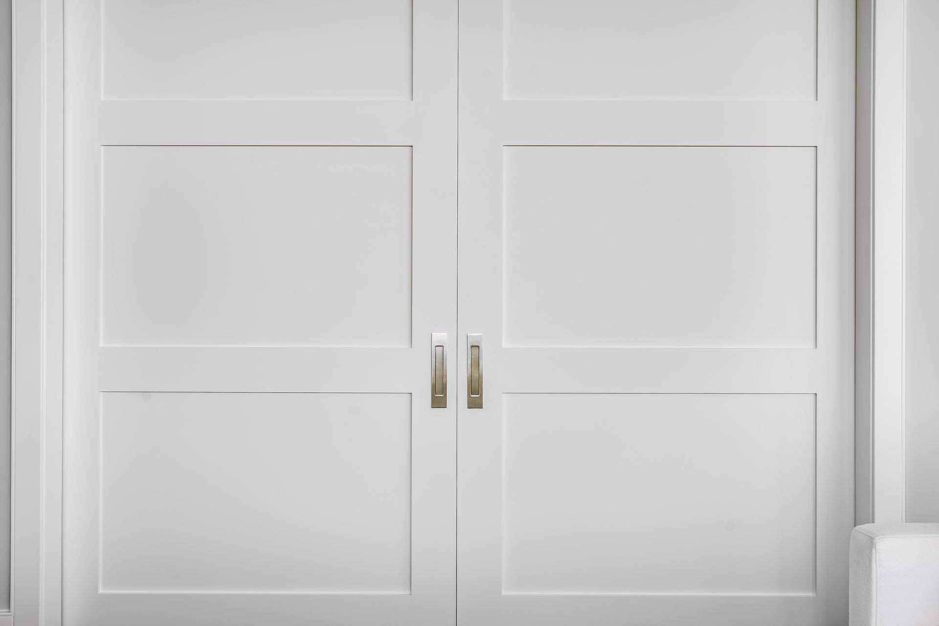 A close up of a pair of white doors in a room.