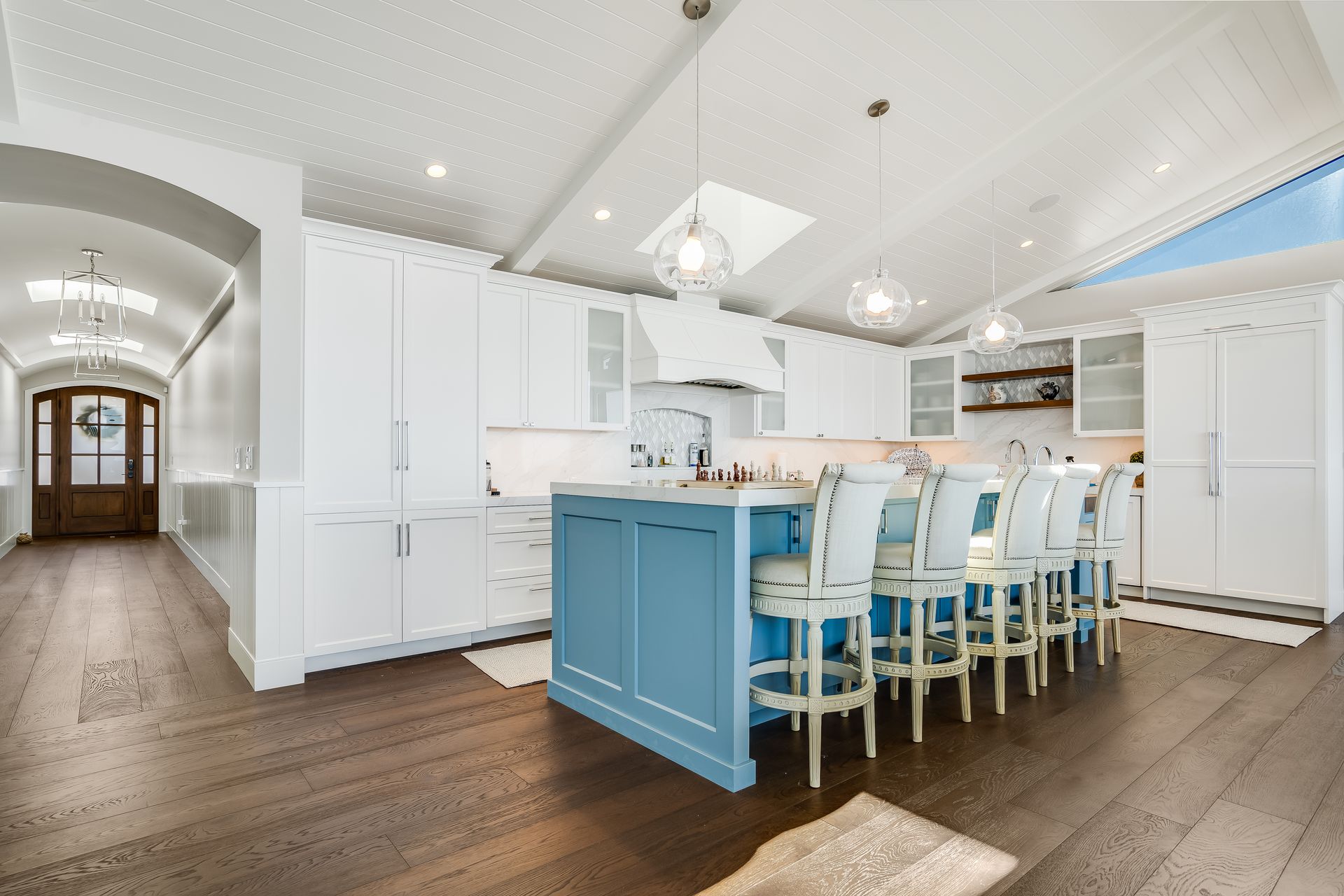 A large kitchen with a blue island and white cabinets