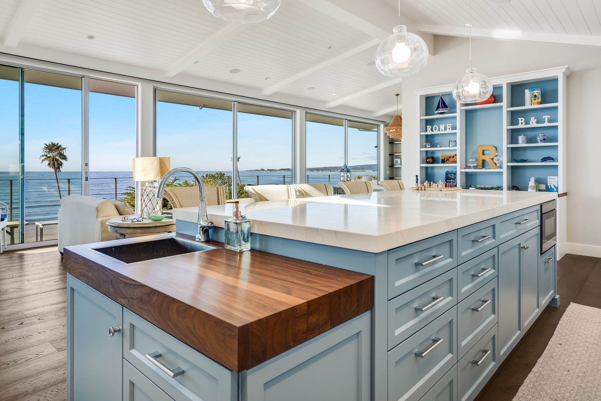 A kitchen with blue cabinets and a large island with a wooden counter top.