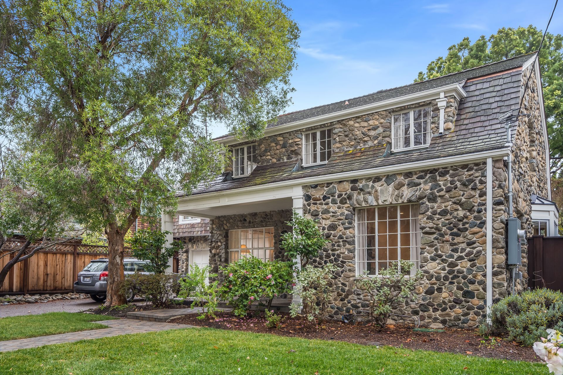 A large stone house with a car parked in front of it.