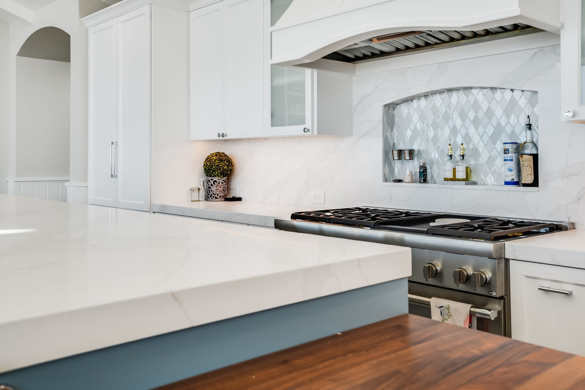 A kitchen with a stove top oven and a wooden counter top.