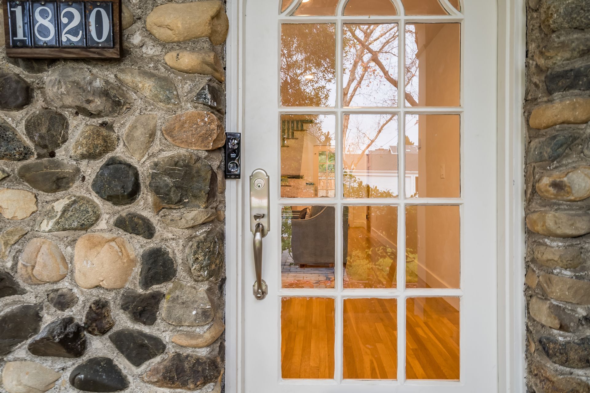 A white door is sitting in front of a stone wall.