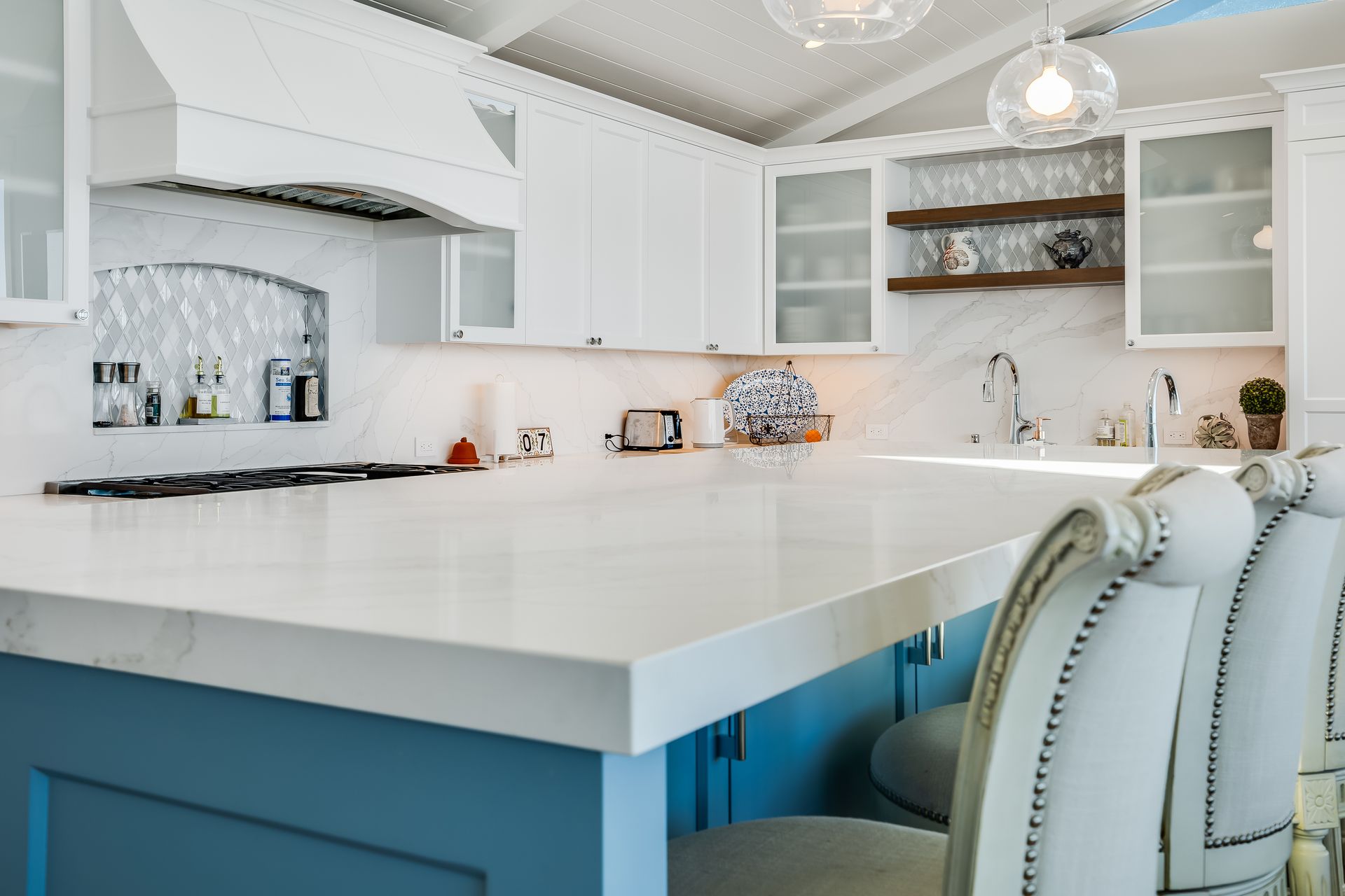 A kitchen with blue cabinets and white counter tops.