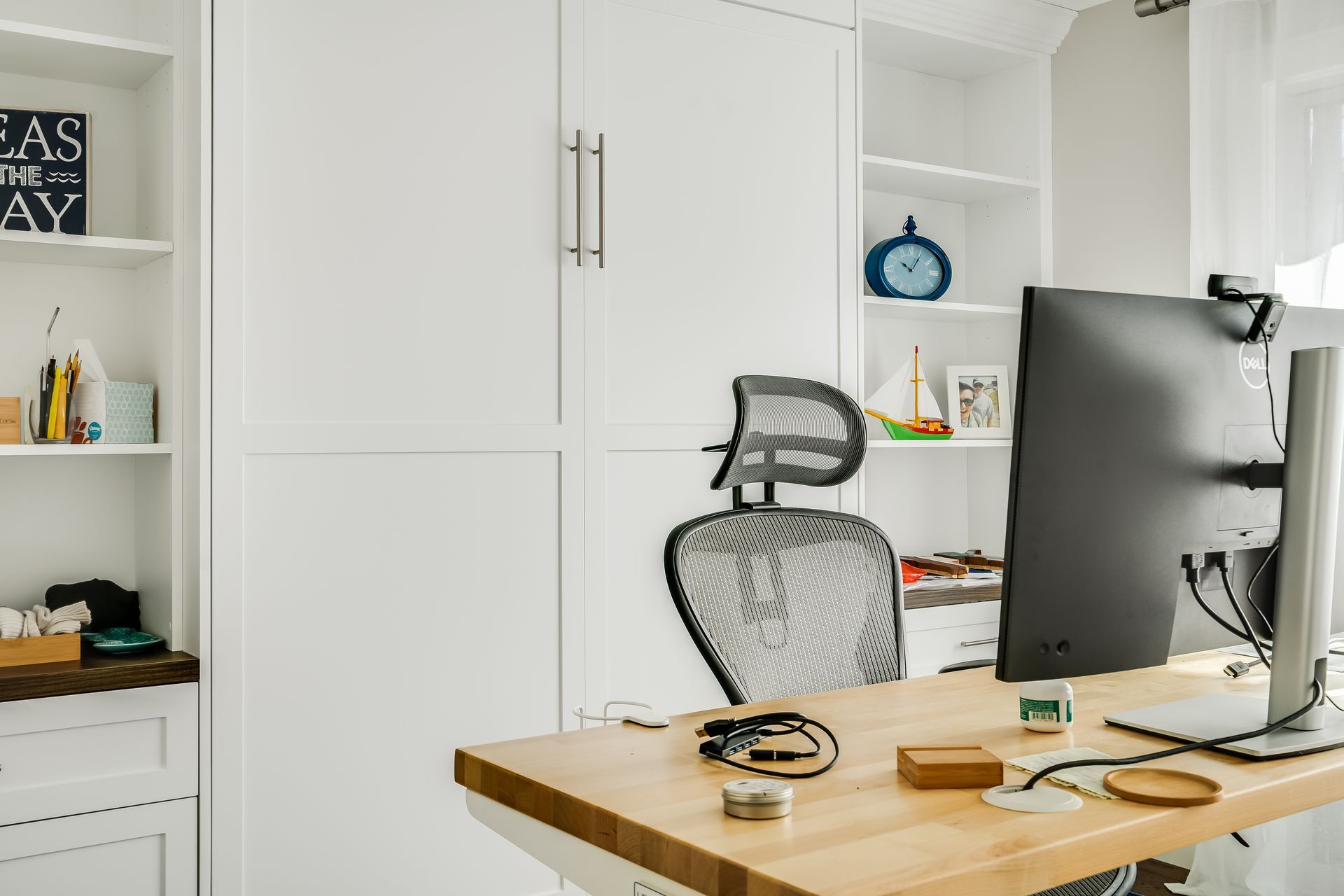 A wooden desk with a computer and a chair in an office.