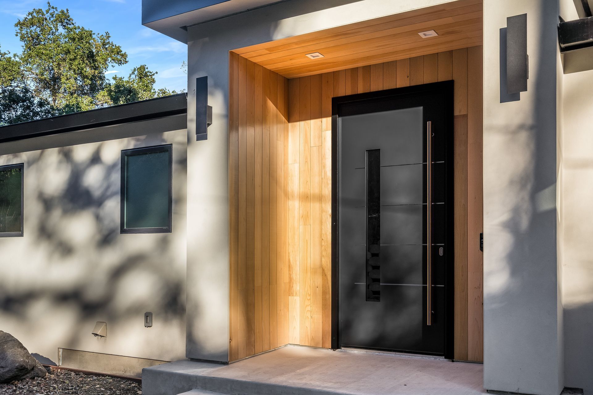 A modern house with a wooden door and a black door