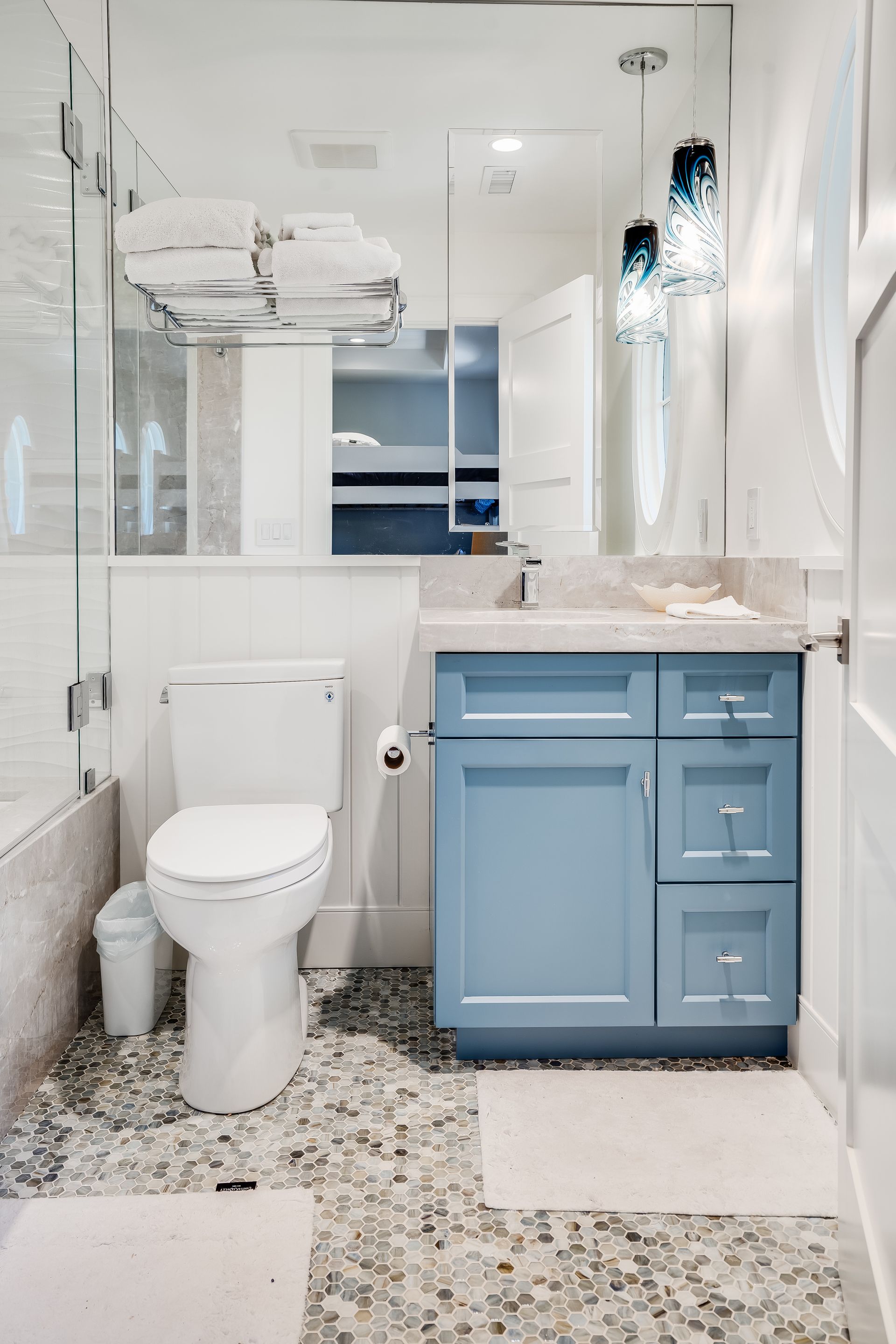 A bathroom with a toilet , sink , and mirror.