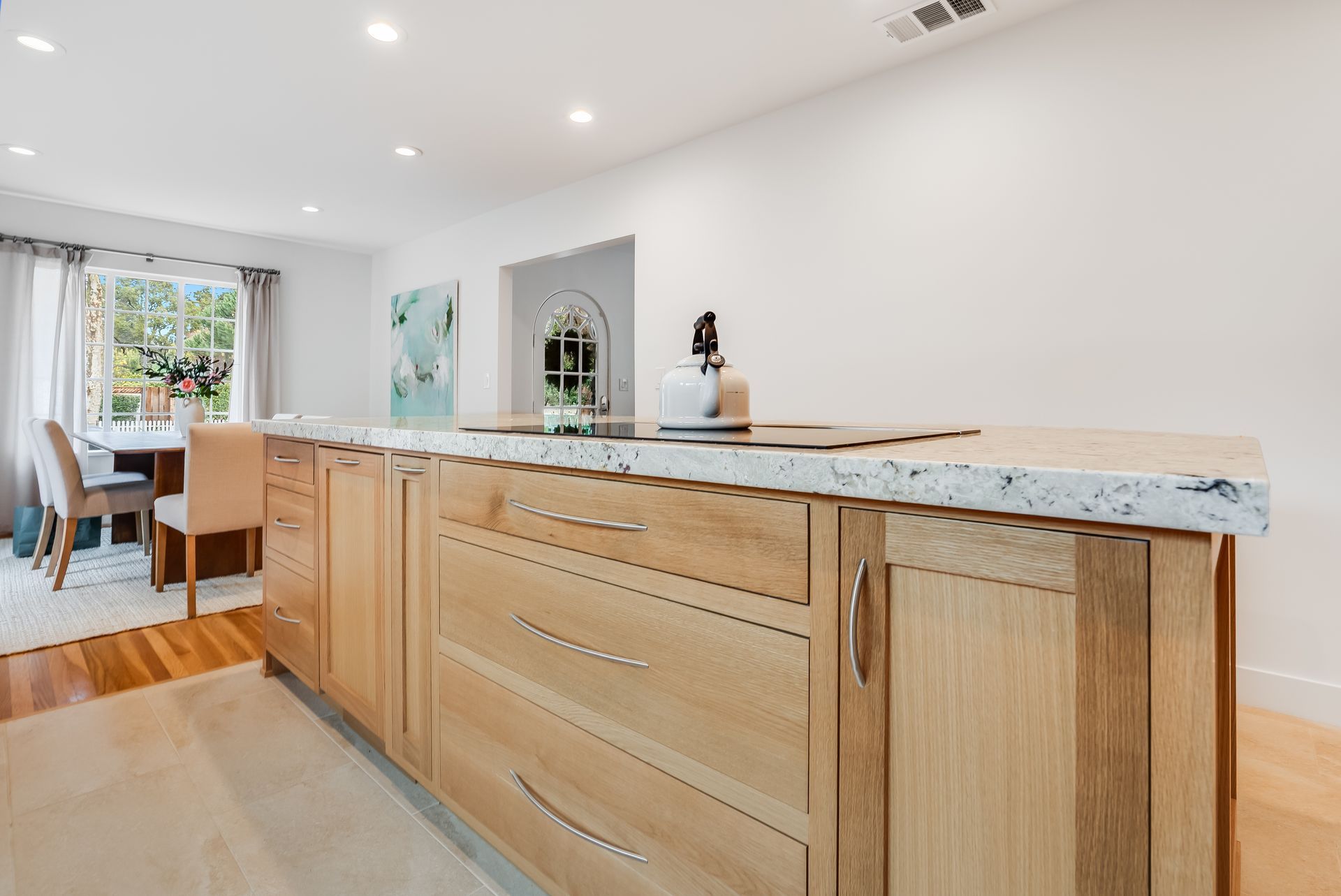 A kitchen with wooden cabinets and a marble counter top.