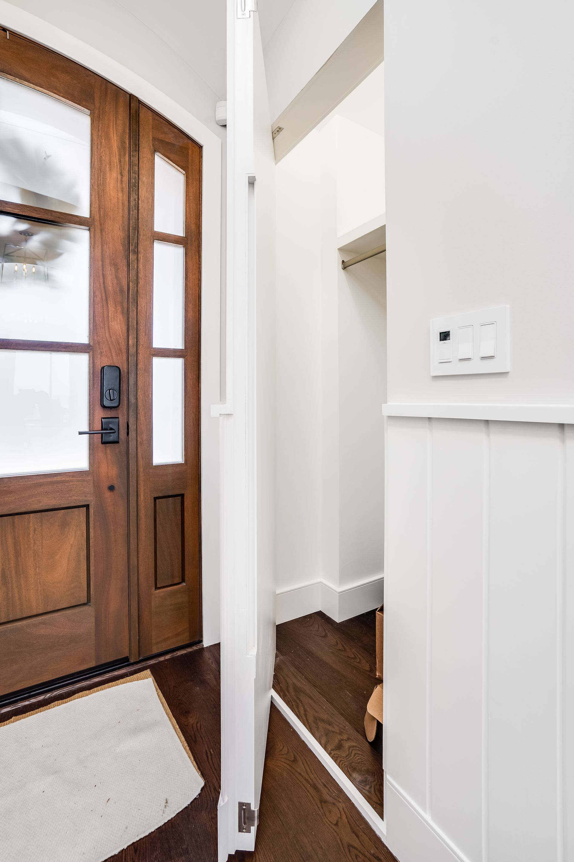 A hallway with a wooden door and a white wall.