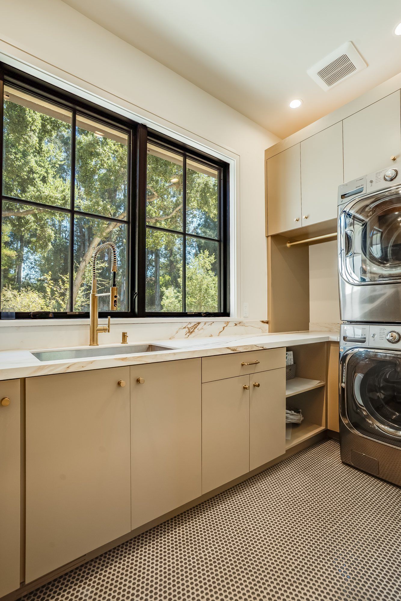 Laundry room cabinetry and storage beneath a window