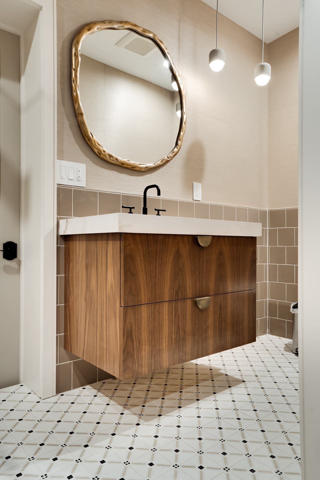 Walnut vanity and round mirror in the powder room