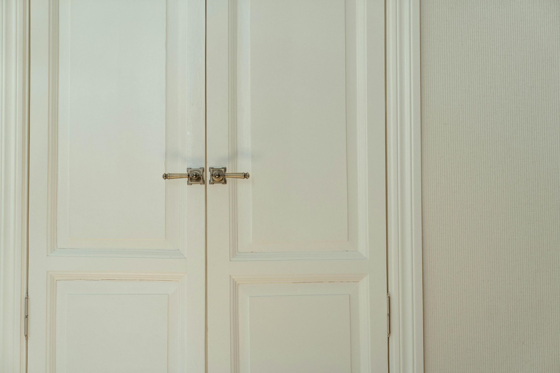 A close up of a pair of white doors in a room.