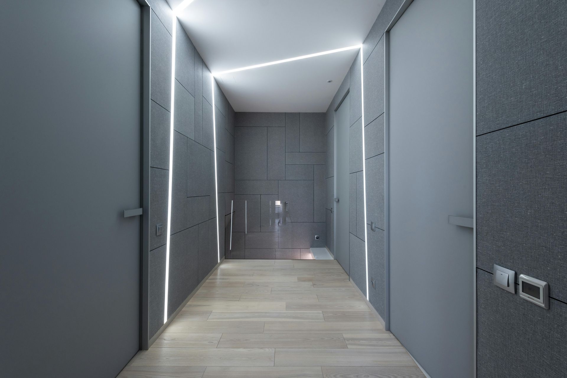 A hallway with a lot of doors and a light on the ceiling.