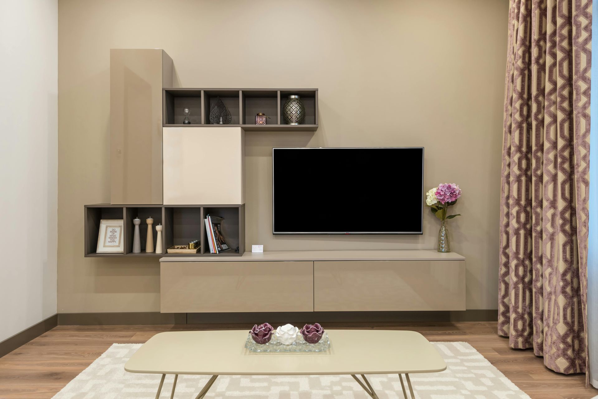 A living room with a flat screen tv and a coffee table.