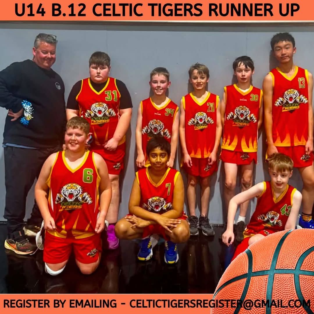 Celtic Tigers runner-up basketball team in red uniforms posing with coach against a gray wall
