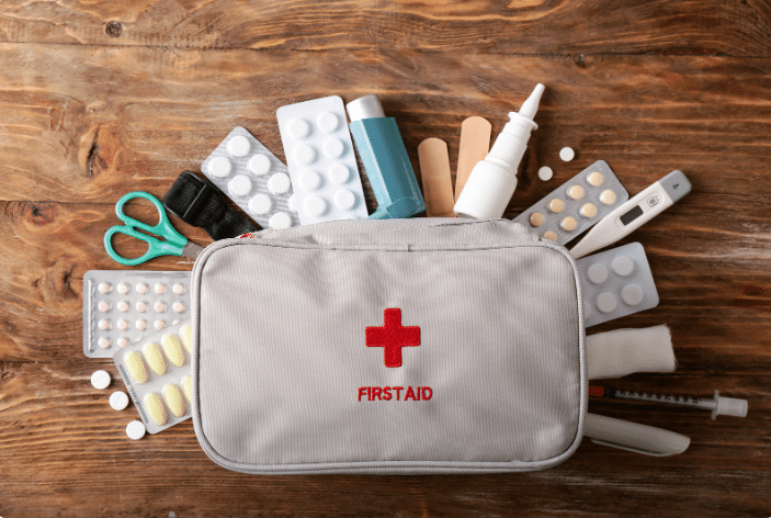 First aid kit with assorted medical supplies on a wooden table
