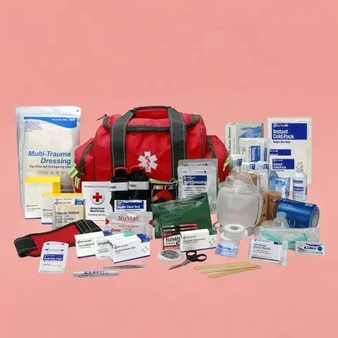Red first aid kit surrounded by assorted medical supplies and bandages on a pink background