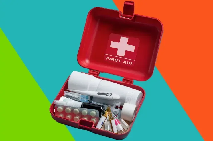 Open first aid kit with medical supplies on a bright teal, green, and orange background