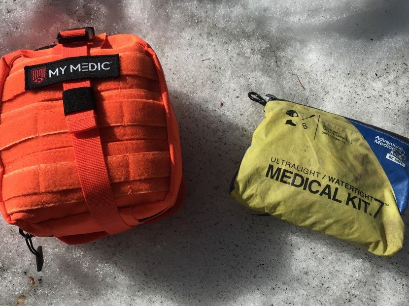 Orange and yellow medical trauma kits on concrete, labeled for emergency use