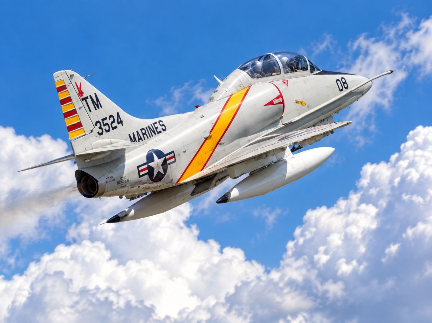 Rick Sharpe flying the TA-4J Skyhawk jet with Marines markings against a blue sky