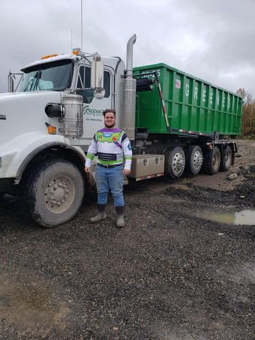 Man in Buzz Lightyear costume stands next to green dump truck on gravel. Man in Buzz Lightyear costume stands next to green dump truck on gravel.