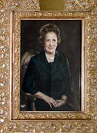 Framed formal portrait of a smiling woman in a dark dress against a dark background