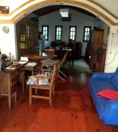 Salón con muebles de madera, sofá azul, puerta en arco y suelo de madera pulida