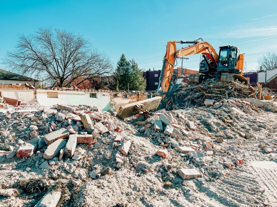 A Construction Site With a Pile of Rubble and a Bulldozer — Husky Demolition In Merewether, NSW