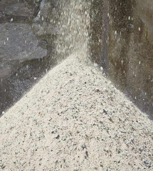 A pile of lead dust is being poured into a container — Husky Demolition In Heatherbrae, NSW
