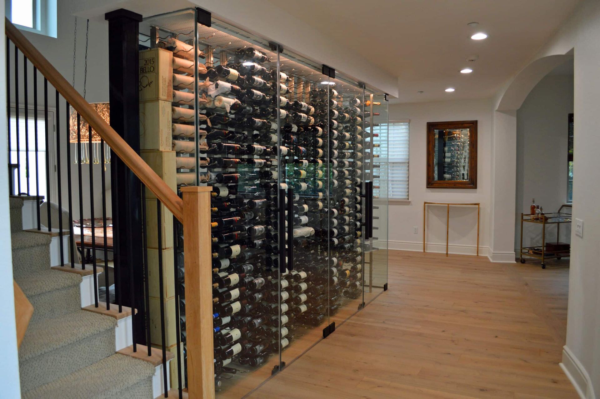 Modern home hallway with a large glass wine rack and hardwood floors