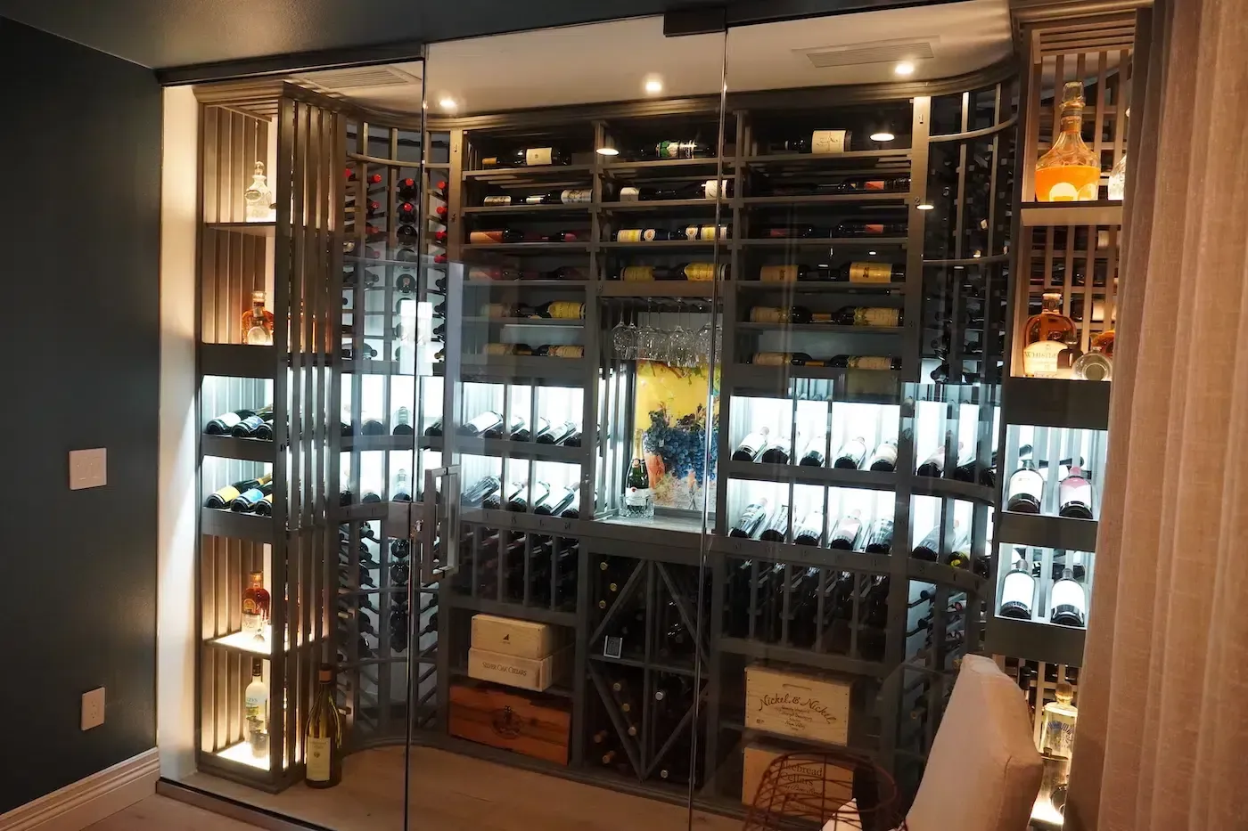 Elegant room with floor-to-ceiling mirrored wine rack, bottles on shelves, and warm ambient lighting