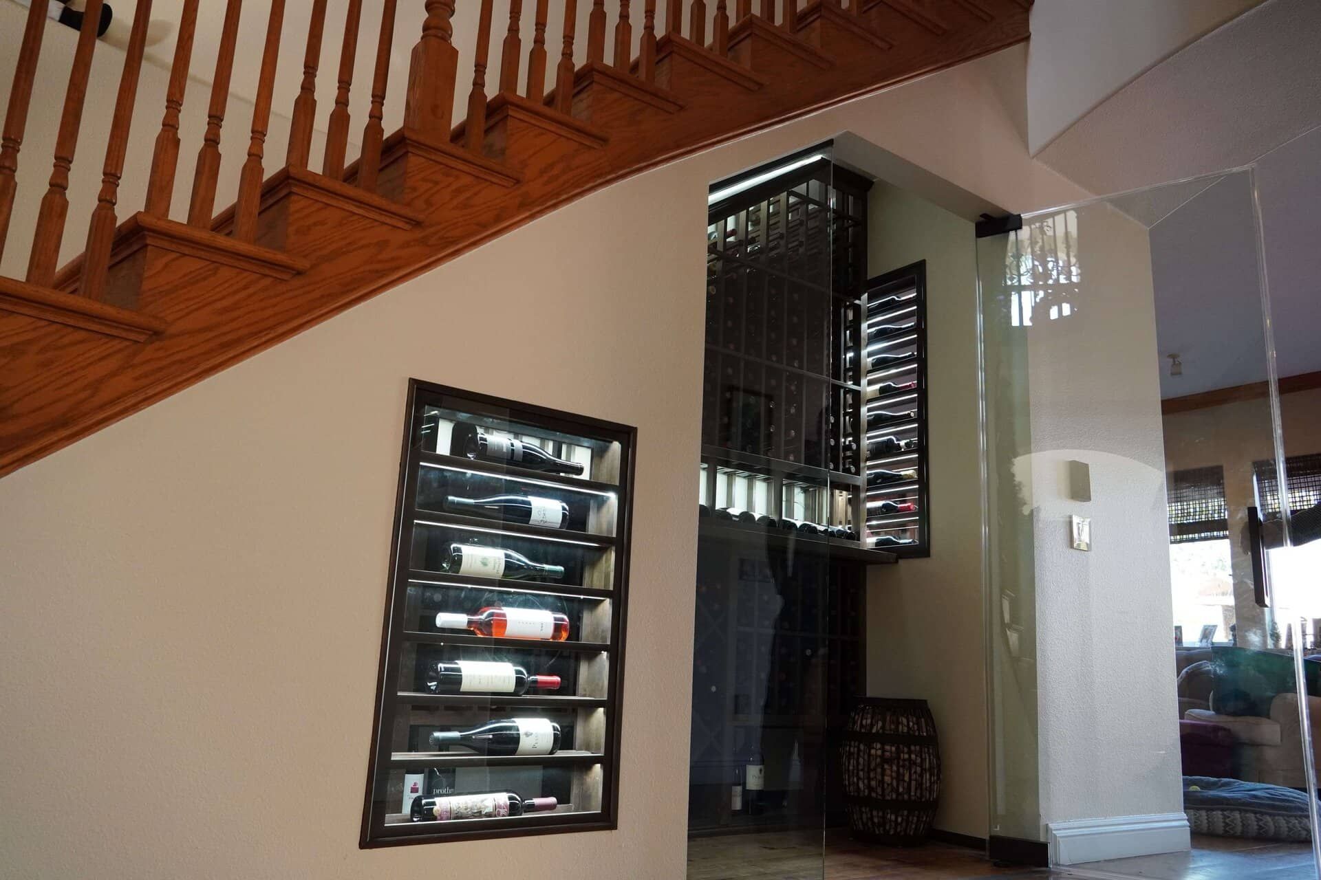 Modern interior with wooden staircase, wine rack, and mirrored wall in a bright room