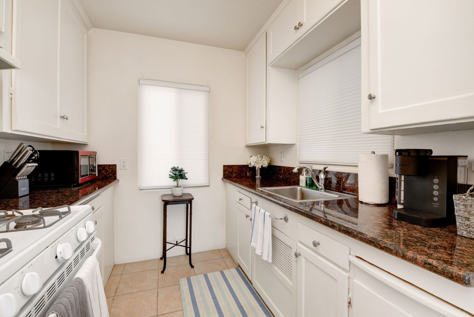 A kitchen with white cabinets and granite counter tops