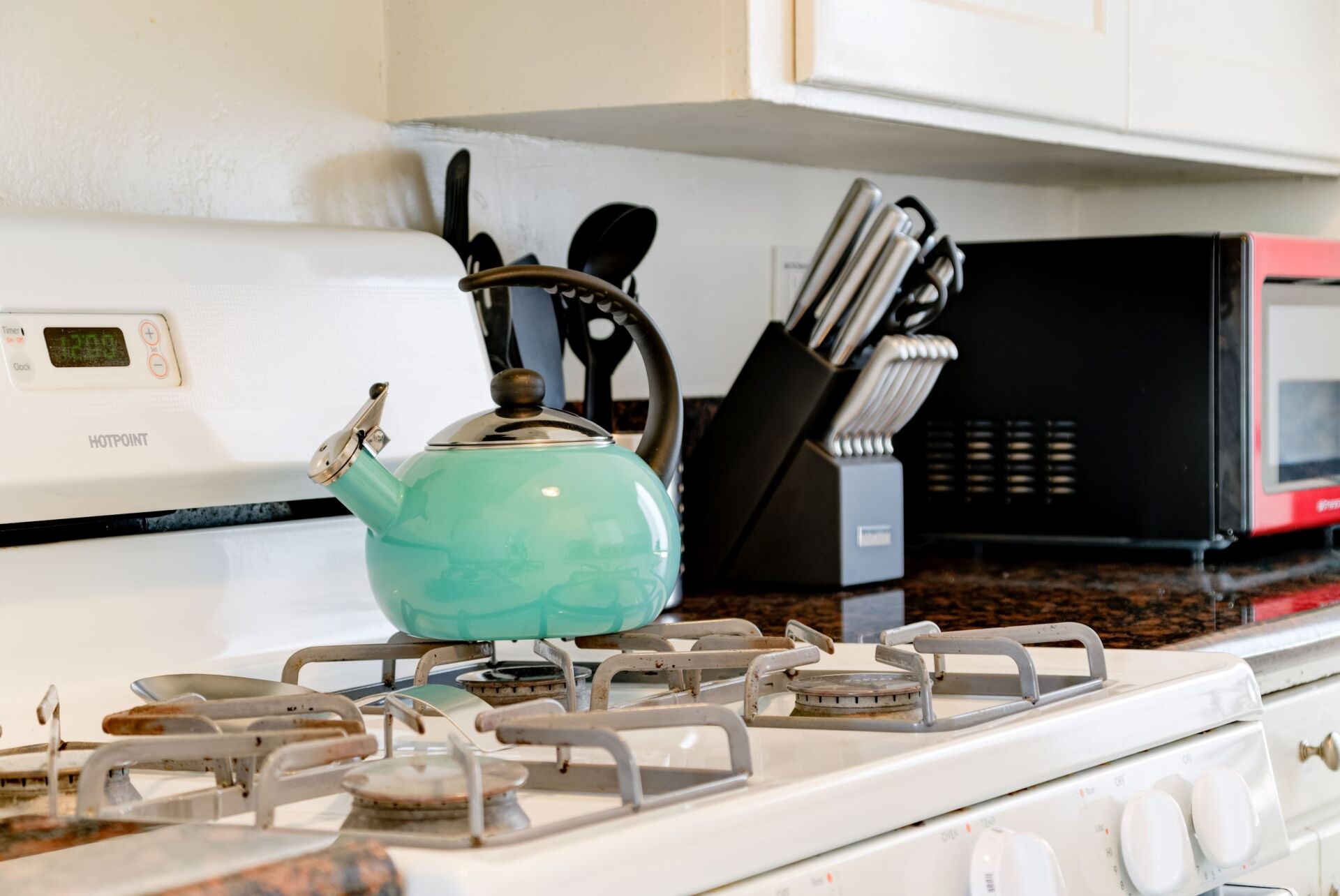 A blue tea kettle is sitting on top of a stove.