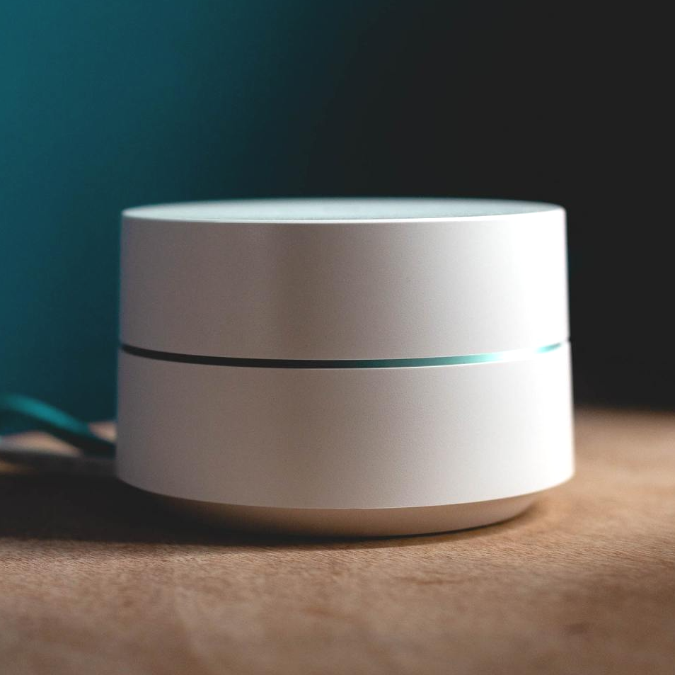 a white speaker is sitting on a wooden table .