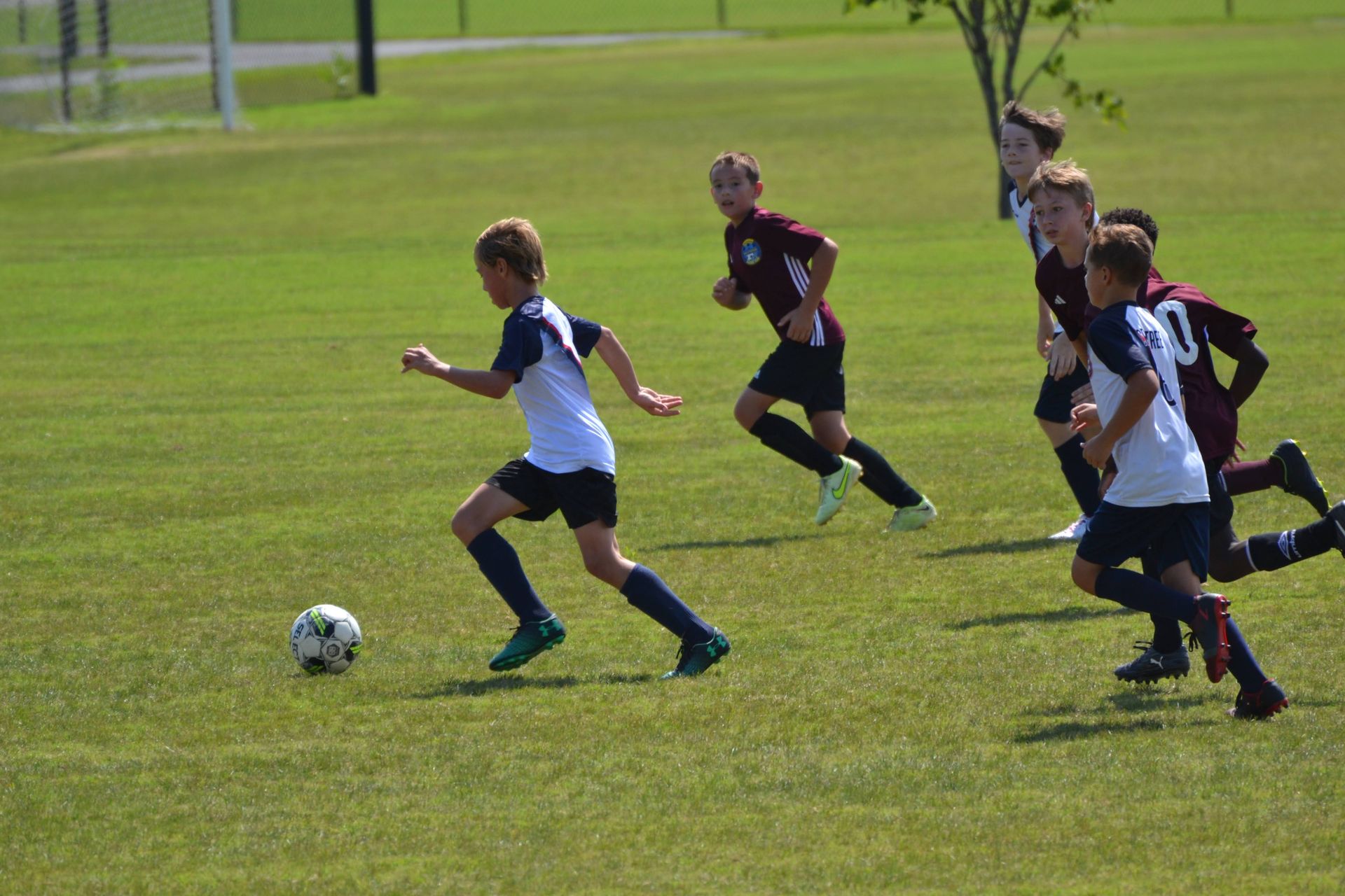 Clarke County Soccer League's female player dribbling. 
