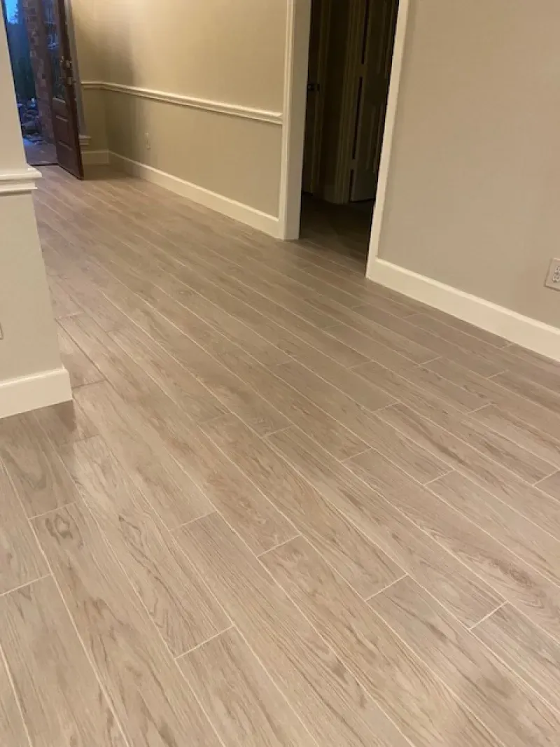 Empty hallway with light wood flooring and beige walls in a home interior.