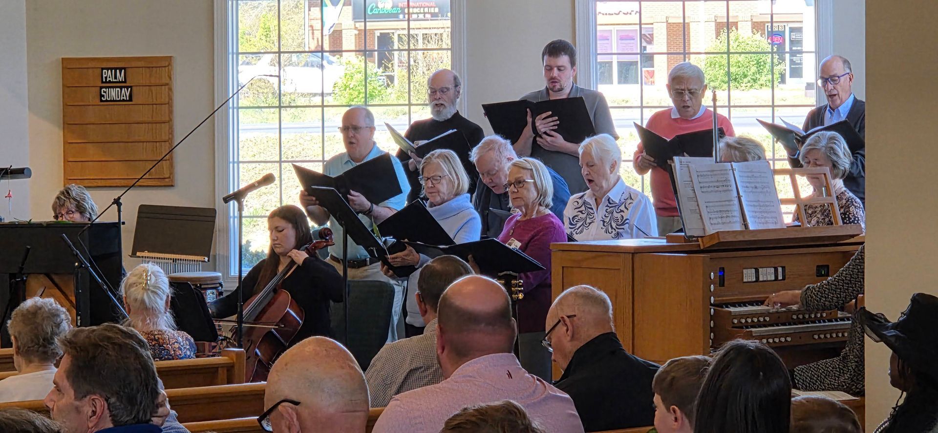 Choir singing in a bright church, with seated audience members