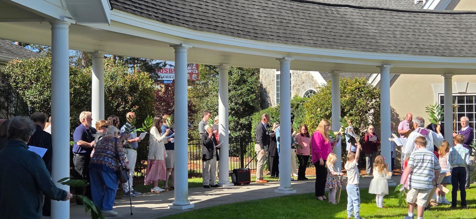 People gathered in a gazebo for Palm Sunday procession.