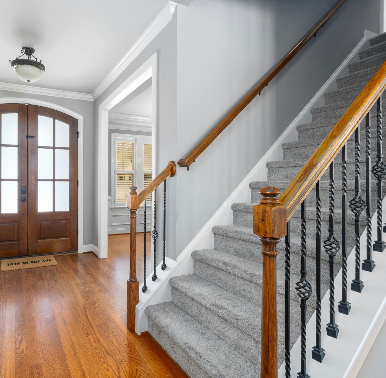A staircase in a house with a welcome mat on the floor