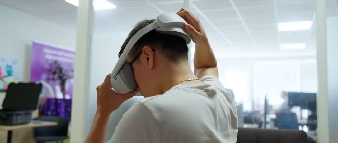 Een persoon zet een VR-bril op in een werkruimte
