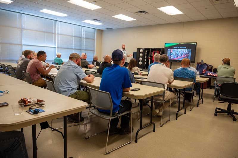 A group attends a presentation in a classroom. 