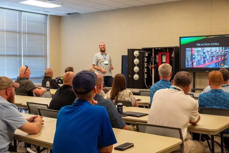 A man presents to a group in a classroom.